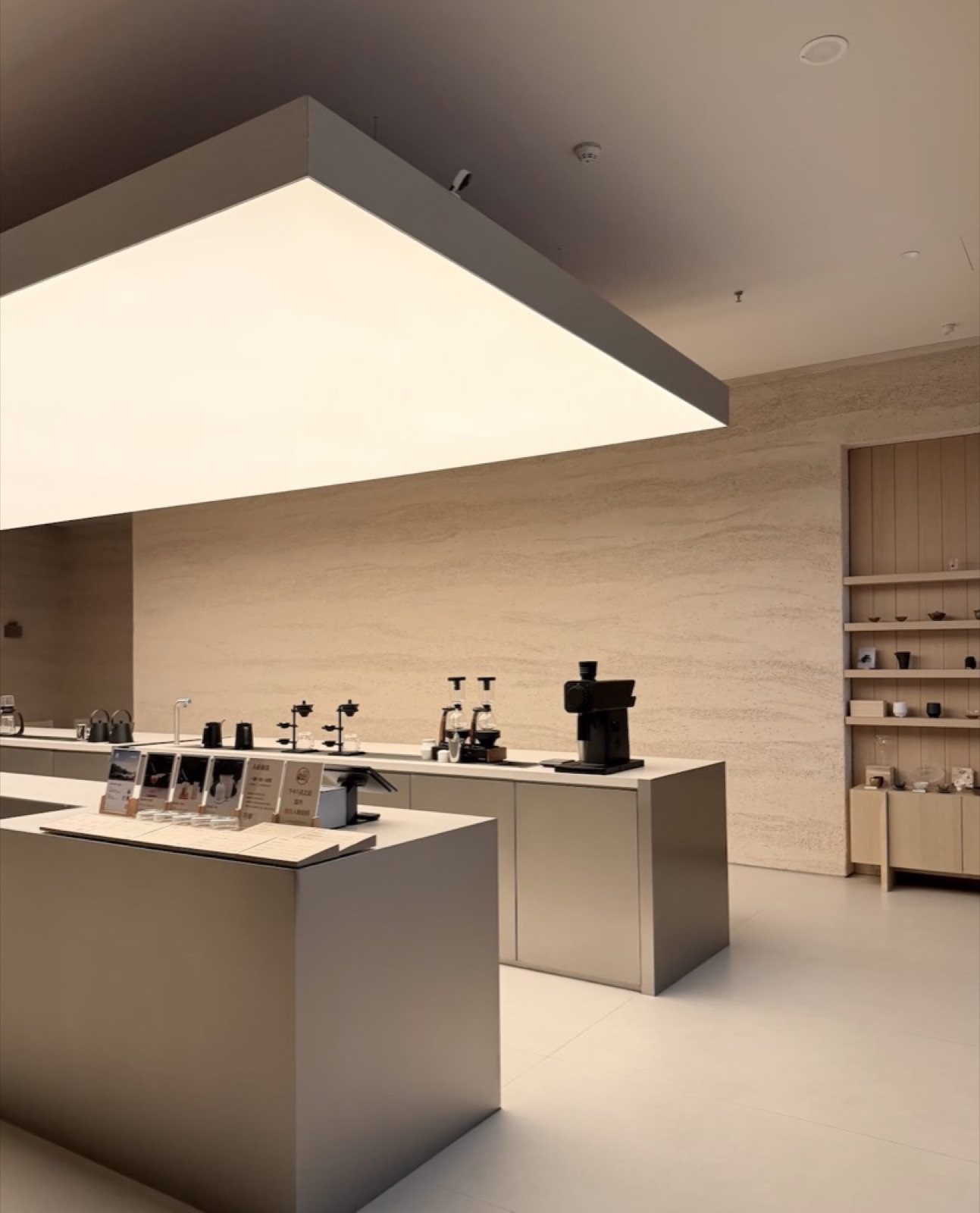 coffee shop minimaliste, comptoir et caisson lumineux au plafond — ayyur interiors.
